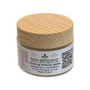 One ounce of Fate Skincare's Healing Beauty Balm presented in a frosted glass jar adorned with a bamboo lid.